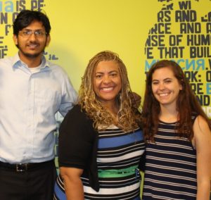 Public education champion Cecily Myart-Cruz poses with members of Corporate Accountability's food team (Deputy Campaigns Director Sriram Madhusoodanan and National Campaign Organizer Alexa Kaczmarski) in front of a mural in Corporate Accountability headquarters.