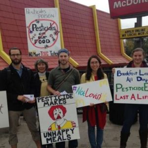 Organizers stand in front of McDonald's store with signs.