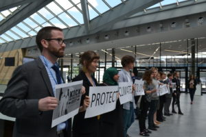 The Federation of Young European Greens and other UNFCCC-accredited youth NGOs organized a silent protest outside the U.N. climate talks, spelling the message “Protect climate policy! Kick big polluters out!” Photo credit: Corporate Accountability International