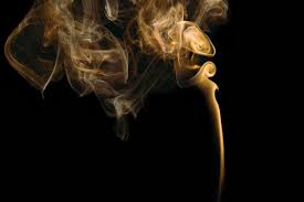 wisps of smoke rising against a black background